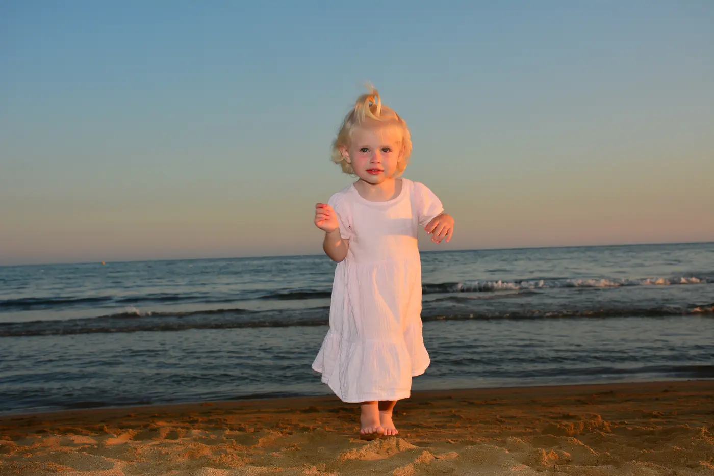 Mädchen im weißen Kleid am Strand